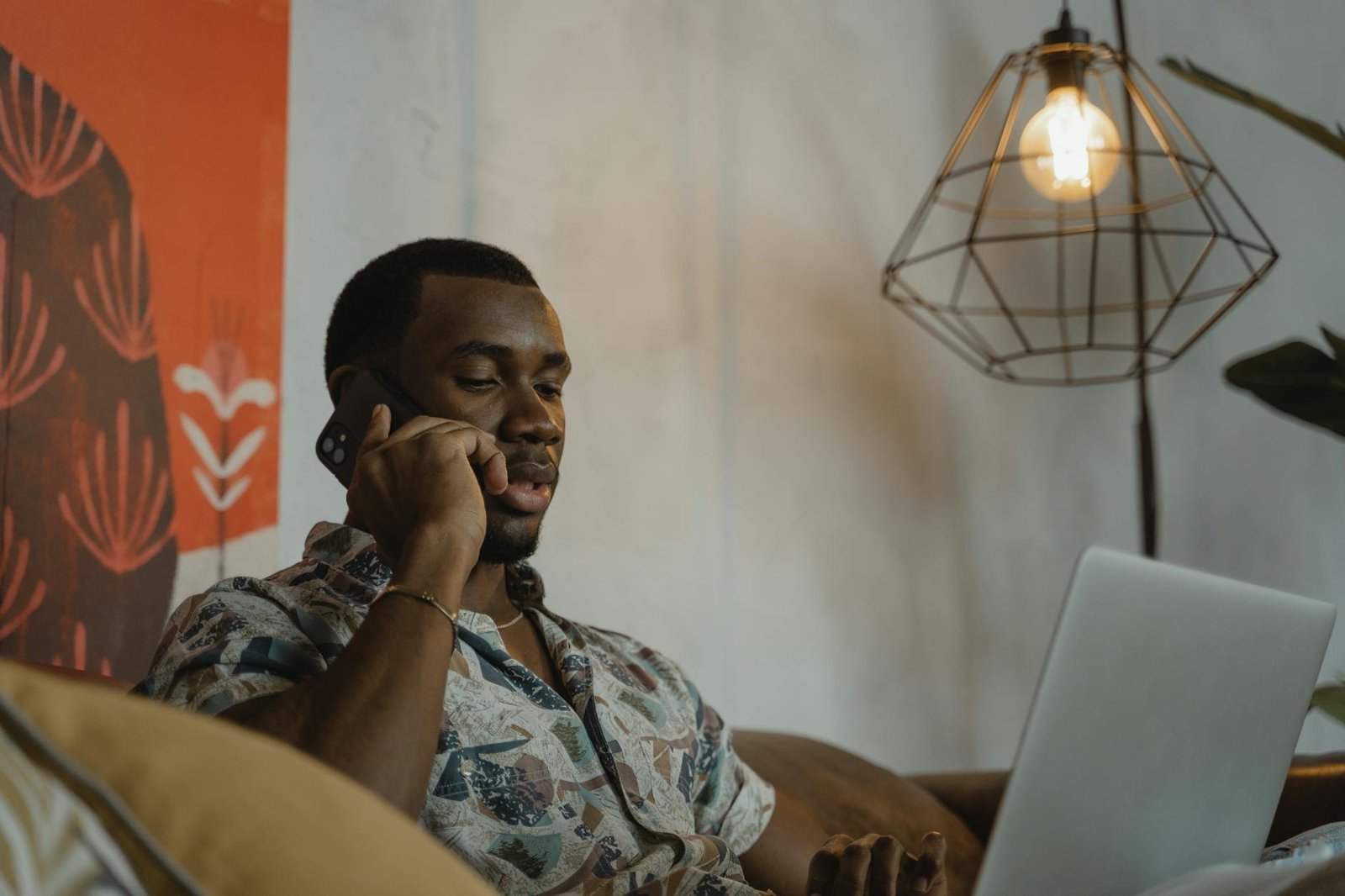 https://www.pexels.com/photo/man-in-gray-and-black-floral-button-up-shirt-sitting-on-brown-couch-5701711/